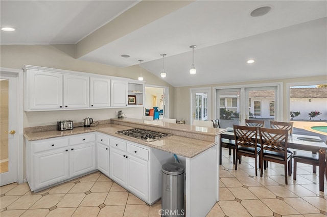 kitchen featuring kitchen peninsula, white cabinetry, stainless steel gas cooktop, and hanging light fixtures