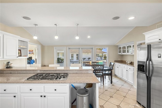 kitchen with light tile patterned floors, white cabinetry, appliances with stainless steel finishes, lofted ceiling, and hanging light fixtures