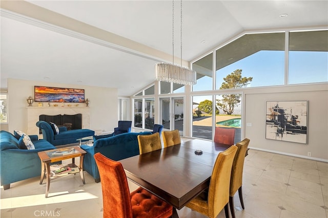 dining area with high vaulted ceiling, expansive windows, and a chandelier