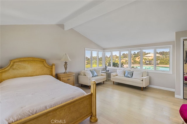 bedroom featuring multiple windows, lofted ceiling with beams, and light wood-type flooring