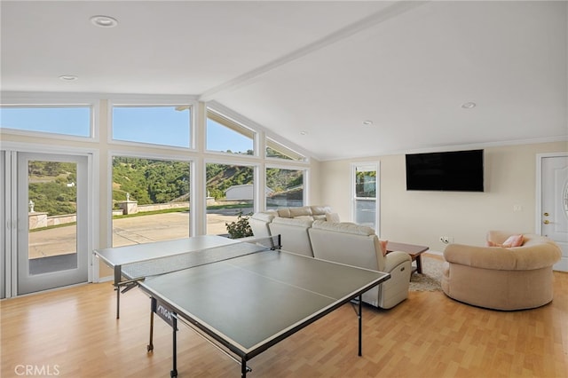 playroom with light wood-type flooring, a wealth of natural light, and lofted ceiling with beams