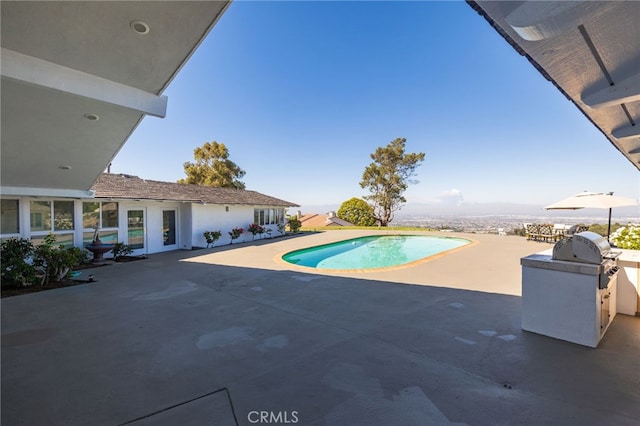 view of swimming pool with grilling area and a patio