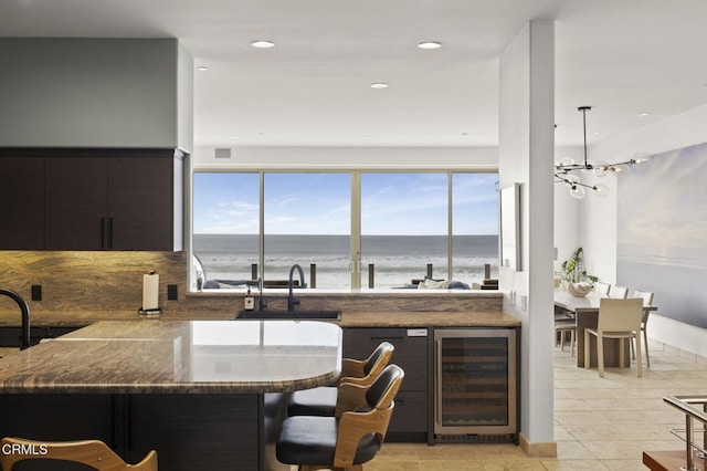 kitchen with a water view, wine cooler, plenty of natural light, and sink