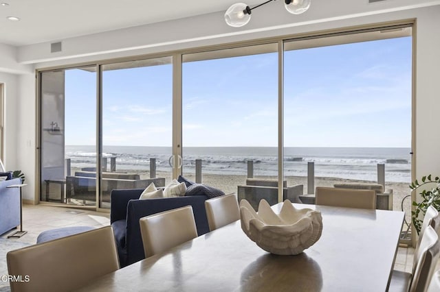 dining area with a water view and a view of the beach