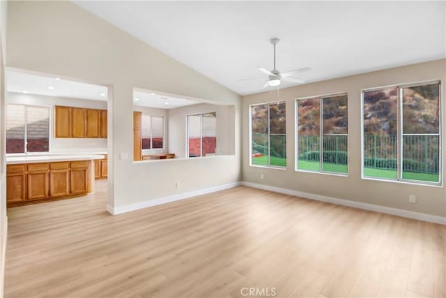 unfurnished living room with ceiling fan, lofted ceiling, and light hardwood / wood-style floors