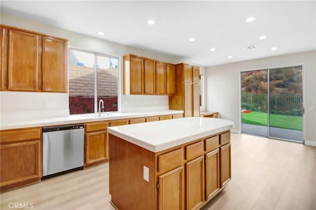 kitchen with light hardwood / wood-style flooring, dishwasher, sink, and a kitchen island