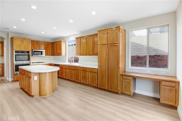 kitchen featuring light hardwood / wood-style floors, sink, stainless steel appliances, and a kitchen island