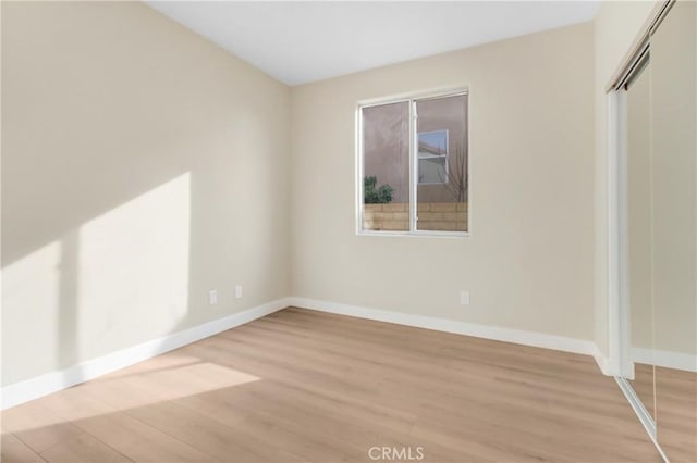 unfurnished bedroom with a closet and light hardwood / wood-style floors