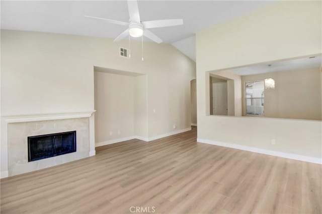 unfurnished living room featuring ceiling fan, vaulted ceiling, a fireplace, and light hardwood / wood-style floors