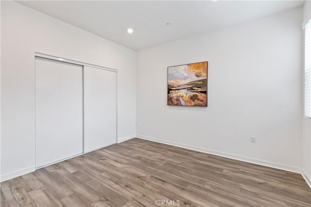 unfurnished bedroom with a closet and wood-type flooring