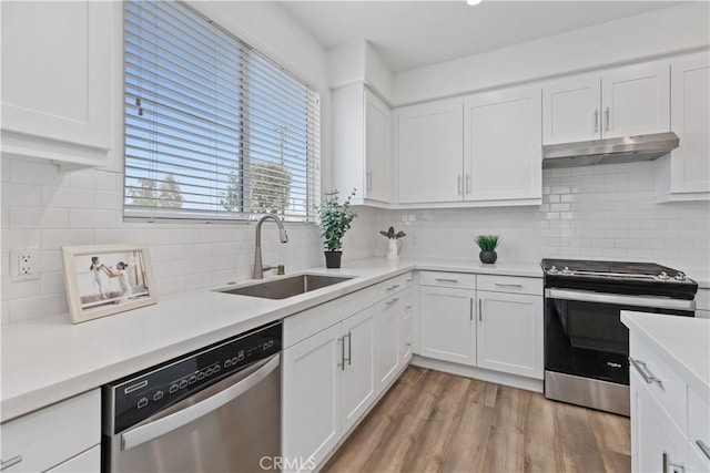 kitchen with sink, white cabinetry, backsplash, and stainless steel appliances