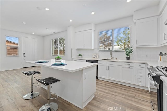 kitchen with sink, white cabinetry, appliances with stainless steel finishes, and a kitchen island