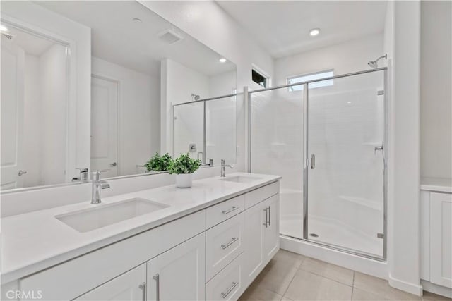 bathroom with vanity, a shower with door, and tile patterned floors