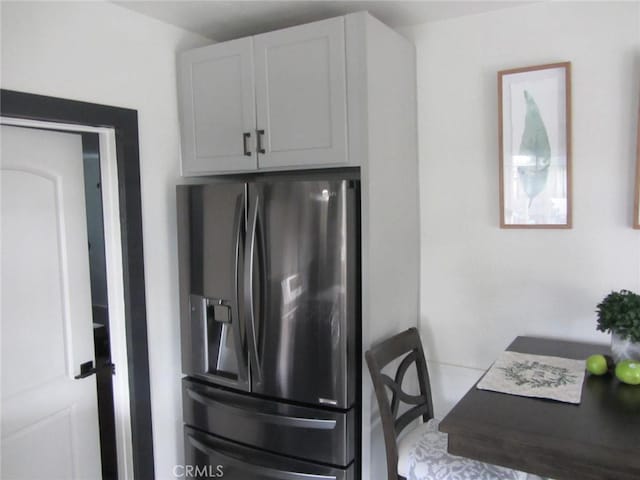 kitchen with white cabinetry and stainless steel fridge