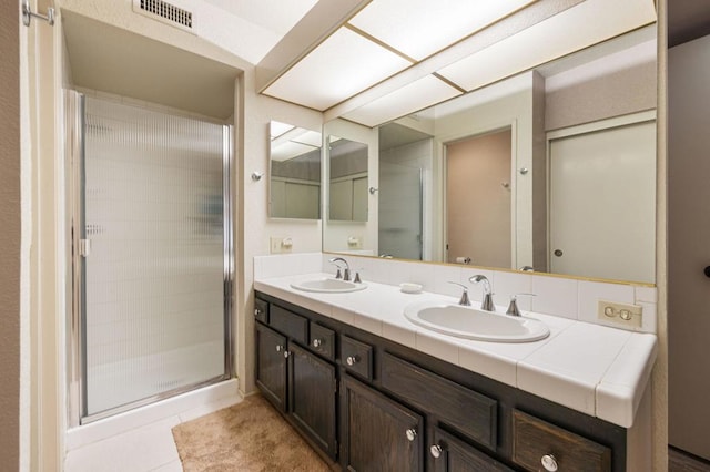 bathroom with vanity, a shower with door, and tile patterned floors