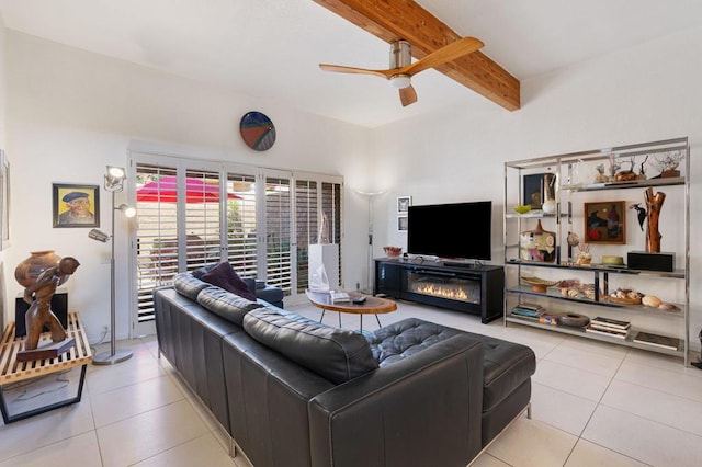 living room featuring ceiling fan, light tile patterned floors, a fireplace, and beamed ceiling