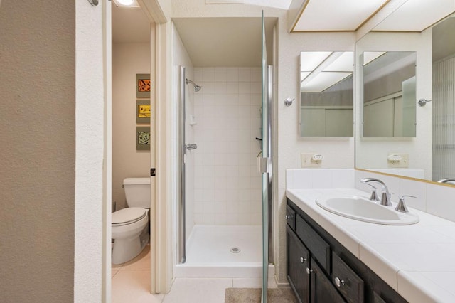 bathroom with toilet, tile patterned floors, an enclosed shower, and vanity