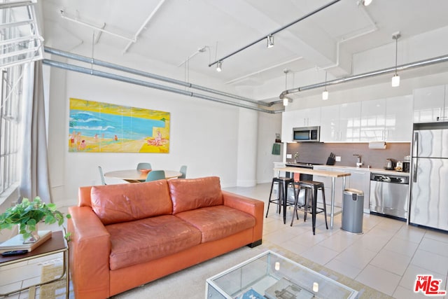 living room featuring light tile patterned floors, sink, and track lighting