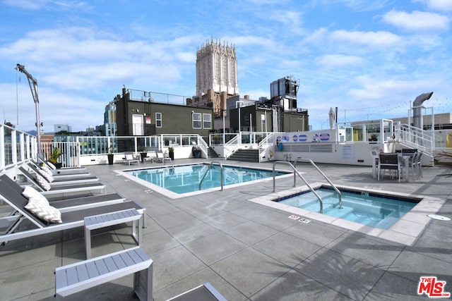 view of swimming pool with a patio area and a hot tub