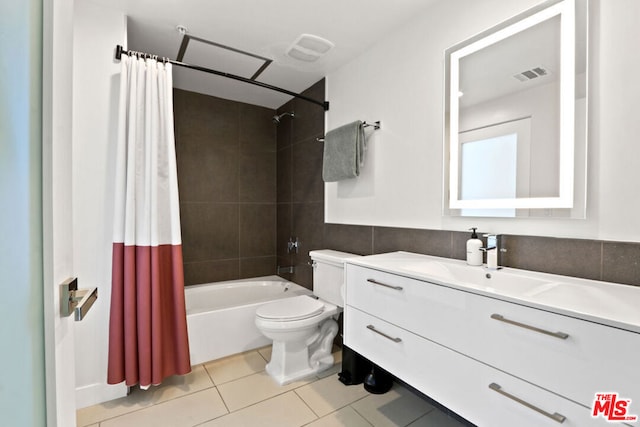 full bathroom featuring tile patterned flooring, vanity, tile walls, toilet, and shower / tub combo with curtain