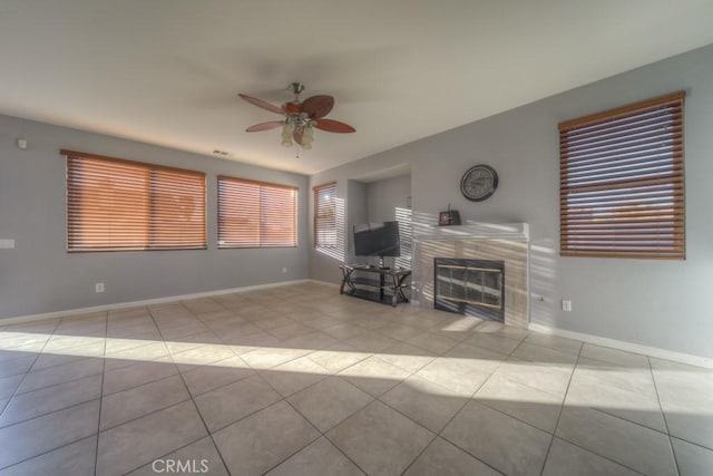 unfurnished living room featuring ceiling fan, light tile patterned floors, and a fireplace