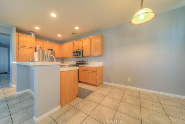 kitchen with light tile patterned floors, stainless steel appliances, light brown cabinetry, and hanging light fixtures