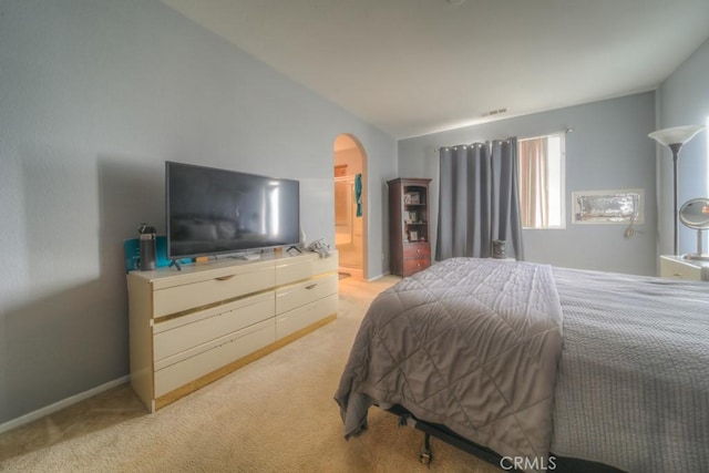 bedroom featuring light colored carpet and vaulted ceiling