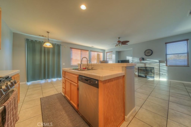 kitchen with tile counters, decorative light fixtures, dishwasher, range, and sink