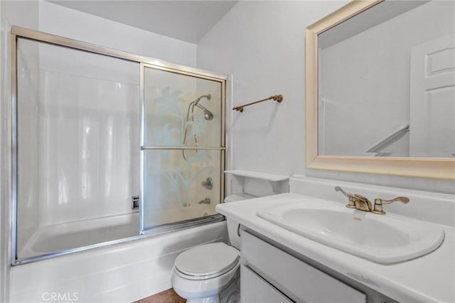 full bathroom featuring enclosed tub / shower combo, vanity, and toilet