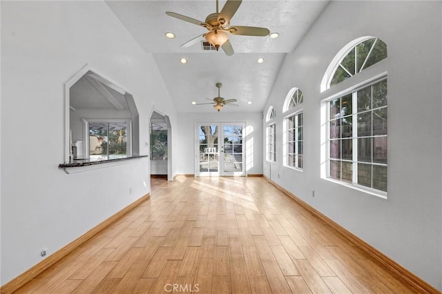 unfurnished living room featuring high vaulted ceiling, light hardwood / wood-style flooring, and ceiling fan