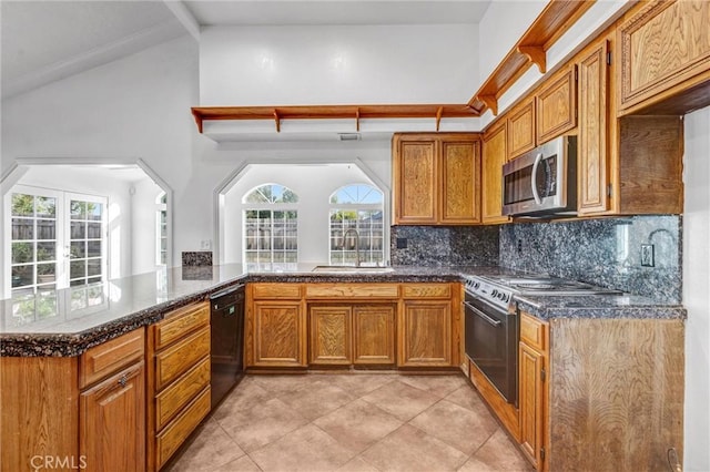 kitchen featuring kitchen peninsula, decorative backsplash, a wealth of natural light, sink, and appliances with stainless steel finishes