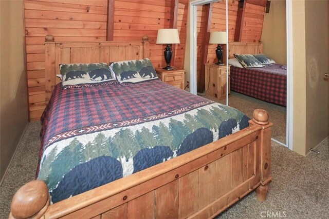 bedroom with light colored carpet and wooden walls