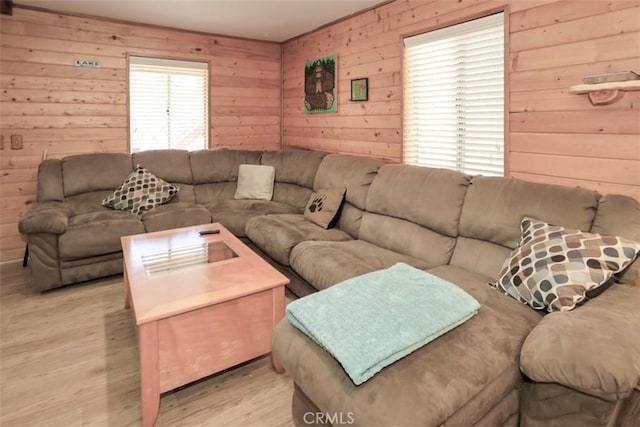 living room with light hardwood / wood-style floors and wood walls