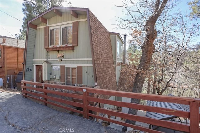 view of front of property featuring a fenced front yard and roof with shingles