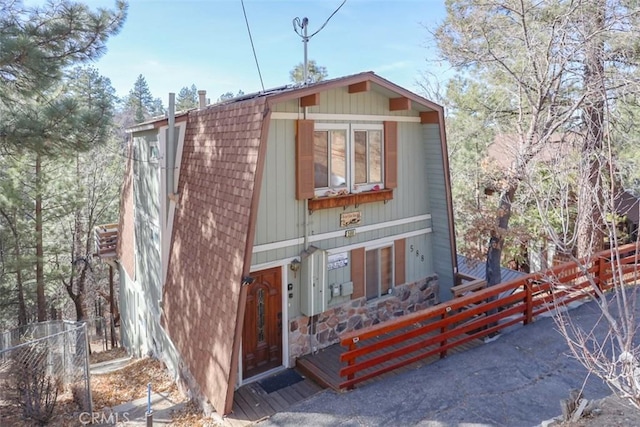 view of front of property featuring stone siding and a fenced front yard