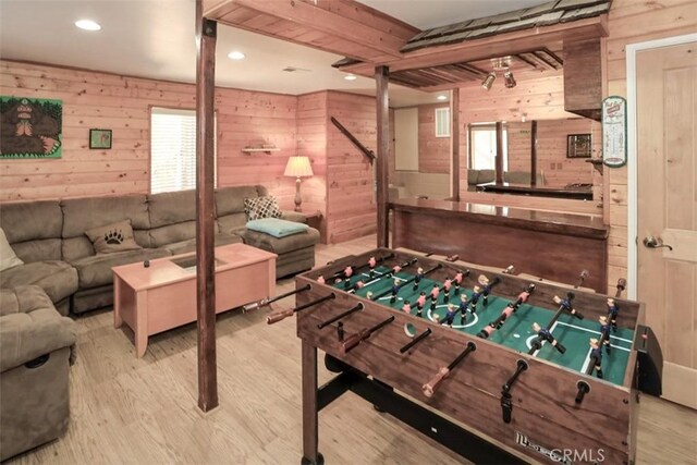 game room with hardwood / wood-style flooring and wood walls