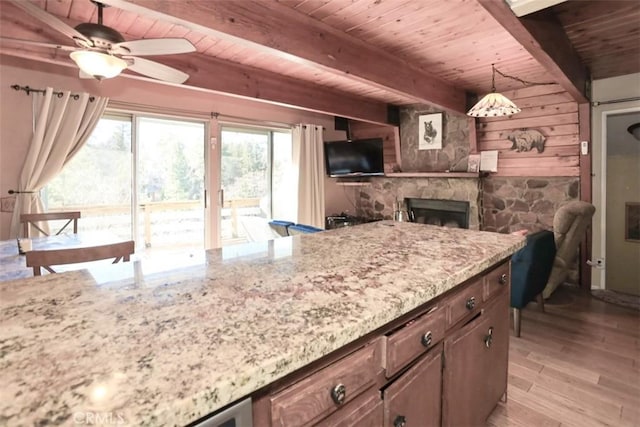 kitchen featuring wooden walls, ceiling fan, decorative light fixtures, light wood-type flooring, and beamed ceiling