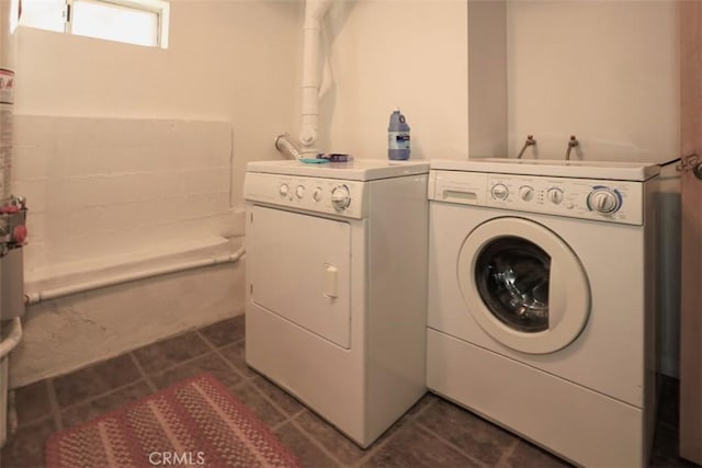 clothes washing area with laundry area, dark tile patterned floors, and washing machine and clothes dryer