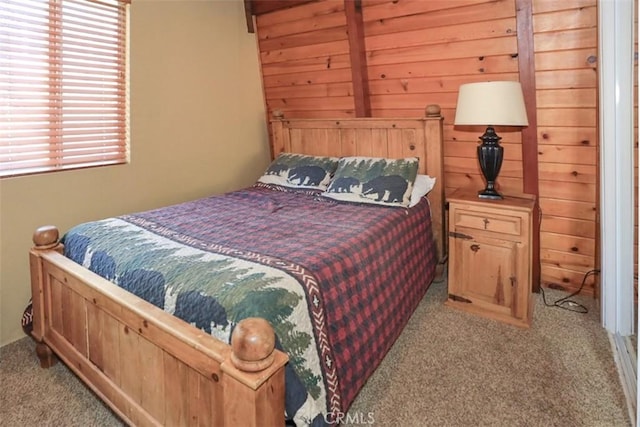 bedroom with wood walls and light carpet