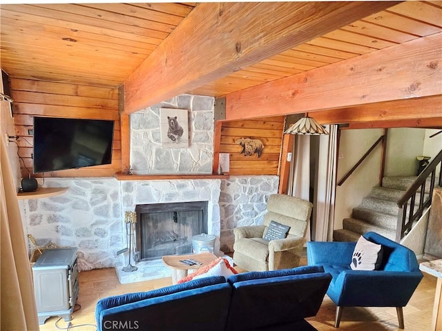 living area featuring stairway, a fireplace, wood finished floors, and wood ceiling