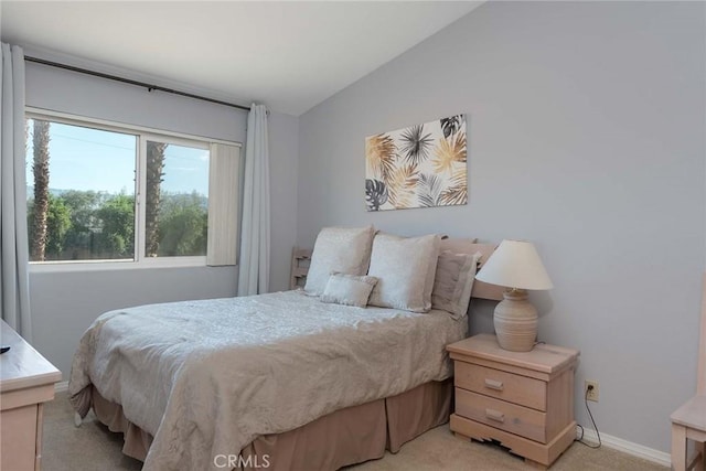 bedroom featuring light colored carpet and lofted ceiling