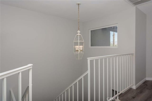 staircase with an inviting chandelier and hardwood / wood-style floors