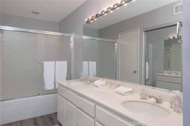 bathroom featuring plus walk in shower, hardwood / wood-style flooring, and vanity