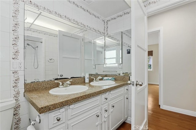 bathroom with toilet, vanity, a shower, and hardwood / wood-style floors