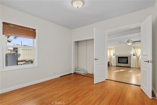 unfurnished bedroom with light hardwood / wood-style floors and beamed ceiling