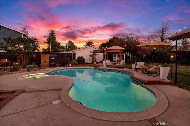 pool at dusk featuring an in ground hot tub, a gazebo, and a patio