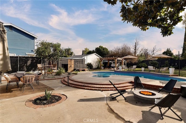 view of swimming pool with a patio area and an outdoor fire pit