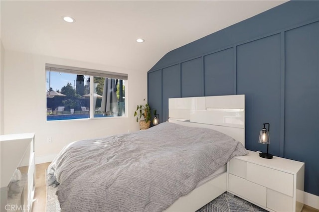 bedroom featuring hardwood / wood-style floors and lofted ceiling