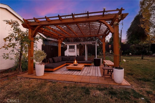 patio terrace at dusk with a wooden deck, a yard, an outdoor hangout area, and a pergola