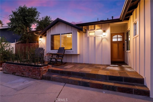 exterior entry at dusk featuring a patio area